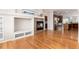 Open living room with stone fireplace and hardwood floors leading into kitchen at 8101 S Quatar Cir, Aurora, CO 80016