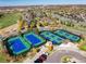 Aerial view of pristine community tennis courts, framed by autumn foliage and picturesque neighborhood at 8101 S Quatar Cir, Aurora, CO 80016