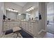 Bathroom featuring dual sinks, granite counters, white cabinets, and tile floors for a sleek design at 8501 S Rome Way, Aurora, CO 80016