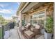 Relax on this covered patio featuring stone accents, ceiling fan, and comfortable wicker furniture with plush cushions at 8501 S Rome Way, Aurora, CO 80016