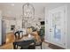 Open-concept dining area with decorative lighting fixture next to the modern kitchen and living room at 8501 S Rome Way, Aurora, CO 80016