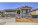 Inviting single-Gathering home featuring a covered porch, stone accents, and an attached two car garage at 8501 S Rome Way, Aurora, CO 80016