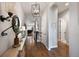 Inviting hallway featuring hardwood floors, modern light fixture, and views of the home's living spaces at 8501 S Rome Way, Aurora, CO 80016
