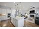 Bright kitchen features a large island, stainless steel appliances, and hardwood floors adjacent to the living room at 8501 S Rome Way, Aurora, CO 80016