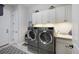 Convenient laundry room with modern washer and dryer set, plenty of storage, and a utility sink at 8501 S Rome Way, Aurora, CO 80016