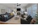 Inviting living room boasts a fireplace, built-in shelving, hardwood floors, and large windows at 8501 S Rome Way, Aurora, CO 80016