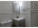 A well-lit bathroom featuring a toilet, sink with cabinet, and a vanity mirror with a light at 5810 S Greenwood St, Littleton, CO 80120