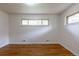Sunlit bedroom features hardwood floors, large windows, and fresh paint at 5810 S Greenwood St, Littleton, CO 80120