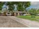 Attractive home featuring a long driveway, mature trees, and a charming brick exterior at 5810 S Greenwood St, Littleton, CO 80120