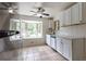 Bright kitchen features tile floors, white cabinets, stainless steel appliances, and a bay window at 5810 S Greenwood St, Littleton, CO 80120