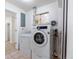 Laundry room features a washing machine, dryer, window, and tile floors at 5810 S Greenwood St, Littleton, CO 80120