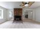 Bright living room showcasing a brick fireplace, neutral carpeting, and seamless flow to other rooms at 5810 S Greenwood St, Littleton, CO 80120
