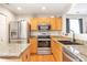 Well-equipped kitchen with stainless steel appliances, granite countertops, warm wood cabinetry, and modern fixtures at 1030 E 78Th Pl, Denver, CO 80229