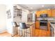 Well-lit kitchen with stainless steel appliances, light wood cabinets, granite counters, and an island with bar seating at 1030 E 78Th Pl, Denver, CO 80229