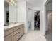 Bathroom with a double sink vanity and an open door to a walk-in closet at 6888 Howell St, Arvada, CO 80004