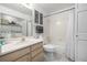 Functional bathroom featuring a vanity, toilet, and shower-tub combo; washer-dryer closet included at 6888 Howell St, Arvada, CO 80004