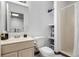 This bathroom has a functional layout, a classic white toilet, a shower, and a mirrored vanity over a neutral-toned cabinet at 6888 Howell St, Arvada, CO 80004