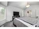 Bedroom featuring a bed with gray bedding, a vaulted ceiling, and access to an adjacent bathroom at 6888 Howell St, Arvada, CO 80004