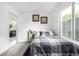 Bright bedroom featuring a bed, window, and view into the adjacent living room at 6888 Howell St, Arvada, CO 80004