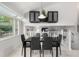 Elegant dining area with a modern light fixture and view of the stairs and living area at 6888 Howell St, Arvada, CO 80004