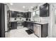 Modern kitchen featuring stainless steel appliances, dark cabinetry, and tiled backsplash at 6888 Howell St, Arvada, CO 80004