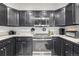 Modern kitchen with stainless steel appliances and dark wood cabinetry and light-colored countertops at 6888 Howell St, Arvada, CO 80004