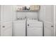 Convenient laundry area with a washer and dryer units plus storage shelving at 6888 Howell St, Arvada, CO 80004