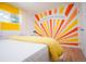 Sunburst wall design in a bright bedroom with minimalist white desk at 7799 Pecos St, Denver, CO 80221