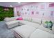 Stylish pink themed living room with a plush sectional sofa, vibrant decor, and playful wall art at 7799 Pecos St, Denver, CO 80221