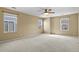 Spacious bedroom features neutral walls, plush carpet, a ceiling fan, and multiple windows at 5779 Ceylon St, Denver, CO 80249