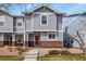 Charming townhome featuring a red door, gray siding, and brick accents at 5779 Ceylon St, Denver, CO 80249