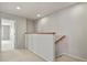 Bright hallway features neutral walls, carpet flooring, and wooden handrail down to the next level at 5779 Ceylon St, Denver, CO 80249