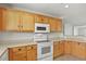 Kitchen features wooden cabinets, white appliances, and bright lighting at 5779 Ceylon St, Denver, CO 80249