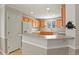 Bright kitchen with wooden cabinetry, white appliances, and a breakfast bar at 5779 Ceylon St, Denver, CO 80249