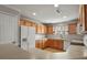 Kitchen with wooden cabinets, white appliances, and an eat-in bar area at 5779 Ceylon St, Denver, CO 80249