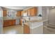 Kitchen with wooden cabinets, white appliances, and tile flooring at 5779 Ceylon St, Denver, CO 80249