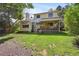 Inviting backyard with lush green grass, a covered deck, and mature trees at 10525 Hobbit Ln, Westminster, CO 80031
