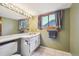 Bright bathroom with a large mirror, window view, and a well-lit vanity at 10525 Hobbit Ln, Westminster, CO 80031