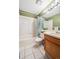 Fresh bathroom with a shower-tub combo, vintage style floors, and oak cabinets at 10525 Hobbit Ln, Westminster, CO 80031