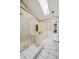 Bright bathroom with a soaking tub under a skylight and a sleek glass-enclosed shower at 10525 Hobbit Ln, Westminster, CO 80031