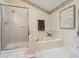 Bathroom showcasing a tub with a sliding glass door, tiled steps, and a floral wallpaper accent at 10525 Hobbit Ln, Westminster, CO 80031