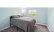 Cozy bedroom with light blue walls, plush gray carpet, and a bright window view at 10525 Hobbit Ln, Westminster, CO 80031