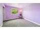 Inviting bedroom bathed in light featuring soft lavender walls and plush neutral carpeting at 10525 Hobbit Ln, Westminster, CO 80031