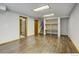 Expansive bonus room with wood flooring, storage shelves, and a versatile layout at 10525 Hobbit Ln, Westminster, CO 80031