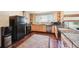 Functional kitchen featuring wooden cabinetry, black appliances, and a breakfast bar perfect for casual dining at 10525 Hobbit Ln, Westminster, CO 80031