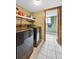 Functional laundry area featuring modern, dark appliances and shelving for ample storage at 10525 Hobbit Ln, Westminster, CO 80031