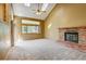Spacious living room with vaulted ceilings, brick fireplace, large windows, skylights and neutral carpet at 10525 Hobbit Ln, Westminster, CO 80031