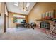 Cozy living room with a fireplace, large windows, vaulted ceilings, and filled with natural light at 10525 Hobbit Ln, Westminster, CO 80031