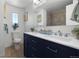 Modern bathroom featuring a double vanity with dark blue cabinetry and a tiled shower at 2575 Quail St, Lakewood, CO 80215