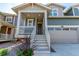 Inviting front porch with white railings, gray steps, and a beautifully landscaped front yard at 17825 Gallup St, Broomfield, CO 80023